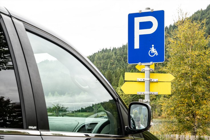 Auto vor Schild für Behindertenparkplatz